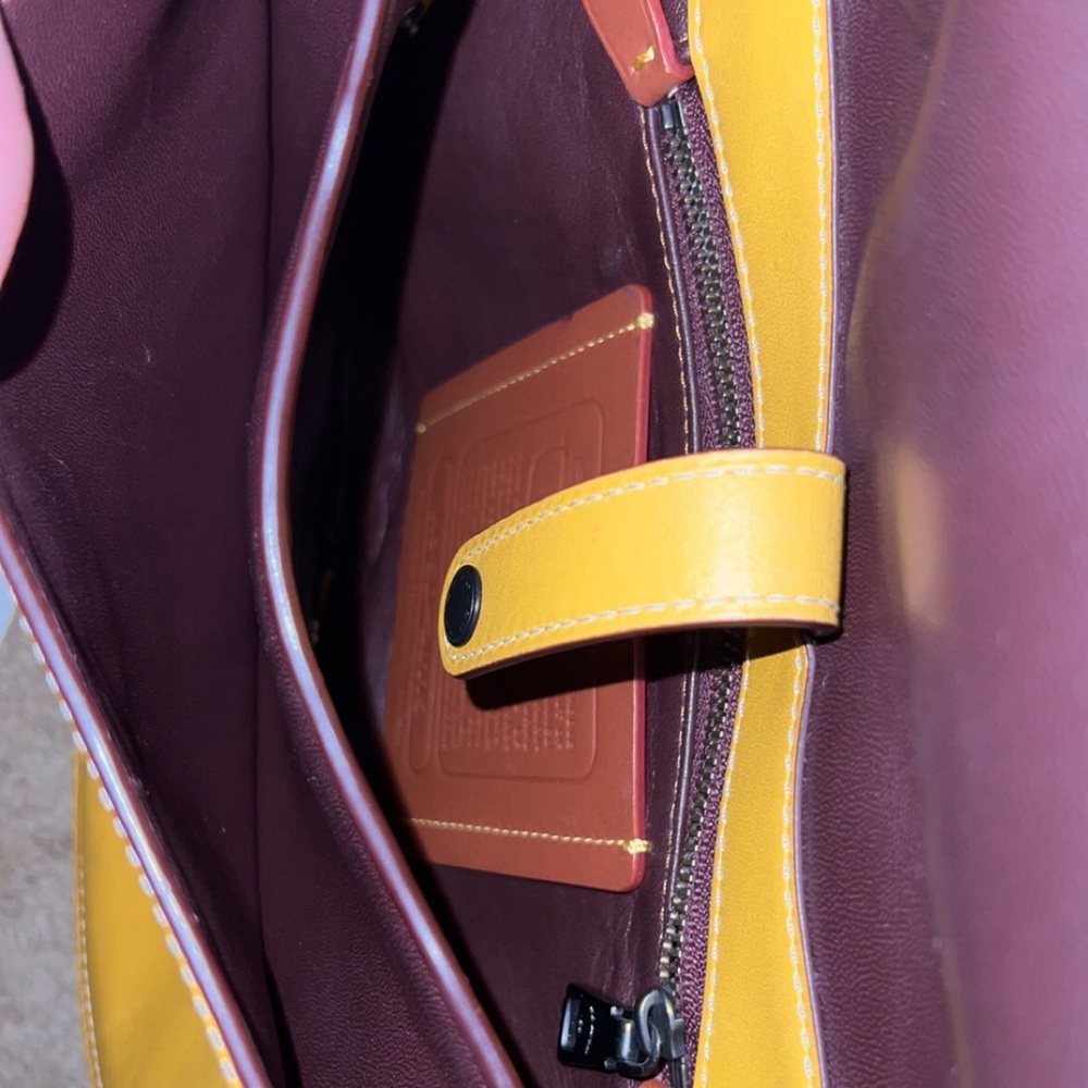 Yellow coach purse with flap and button to close